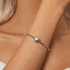 Közeli termékfotó a női csuklón ragyogó csillagos szív kapcsos ezüst bangle karkötőről