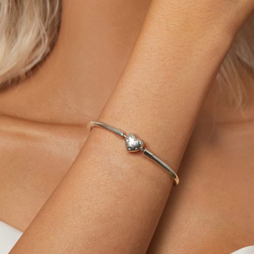 Közeli termékfotó a női csuklón ragyogó csillagos szív kapcsos ezüst bangle karkötőről
