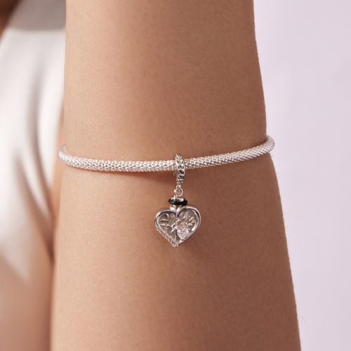 Elegáns ezüst szív charm női csuklón viselve, finom kidolgozással.