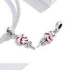 Ezüst hálós karkötőre rögzített színes, játékos nyalóka charm, a háttérben a karkötő elegáns, Love forever feliratú kerek kapoccsal.
