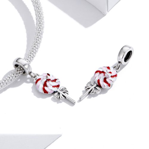 Ezüst hálós karkötőre rögzített színes, játékos nyalóka charm, a háttérben a karkötő elegáns, Love forever feliratú kerek kapoccsal.