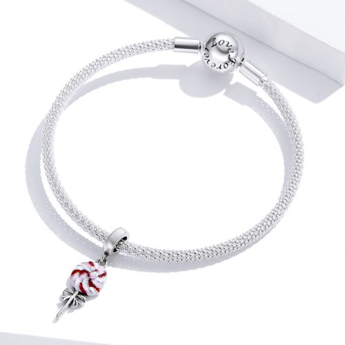 Ezüst hálós karkötőre rögzített színes, játékos nyalóka charm, a háttérben a karkötő elegáns, Love forever feliratú kerek kapoccsal.