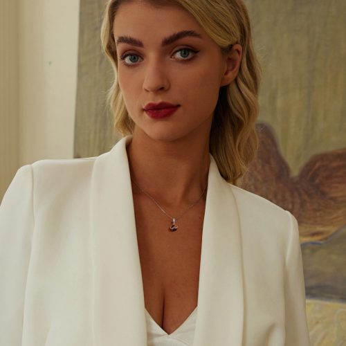 Vékony ezüst nyakláncon függőként viselt tigrisszem bolygó charm egy női nyakon, elegáns viseletként bemutatva.